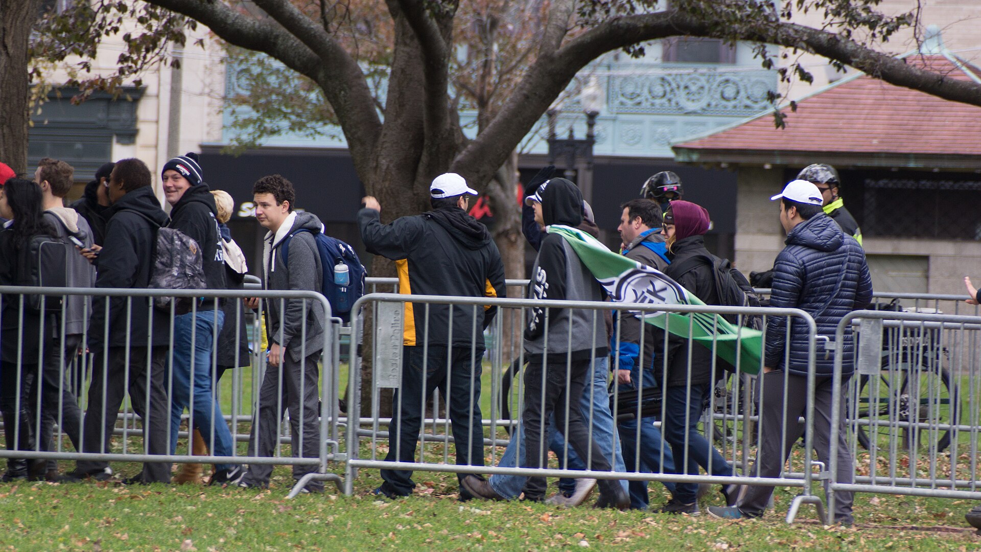 The Kekistan flag worn as a cape, Boston Common, 18 November 2017 — the KEK roundel, which stands in the position of the swastika disc on the flag it parodies. Photo: Marc Nozell, CC BY 2.0, via Wikimedia Commons.